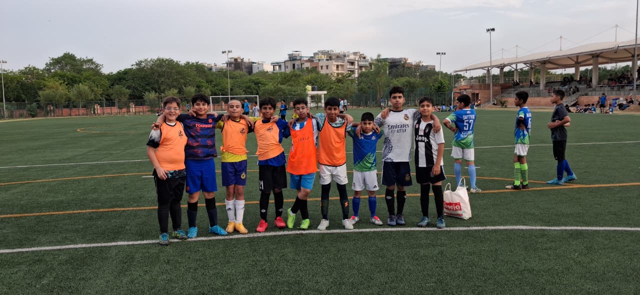 Under-11 players lined up in training bibs on the pitch